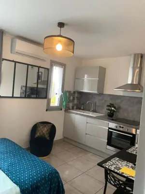 a small kitchen with a bed and a table at LE MONICA in Narbonne