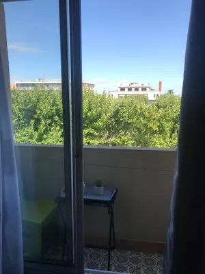 a view of a balcony with a table and a window at LE MONICA in Narbonne