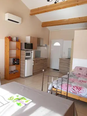 a kitchen and living room with a bed in a room at Studio Meublé non fumeur in Narbonne