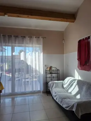 a bedroom with a bed and a view of a patio at Studio Meublé non fumeur in Narbonne