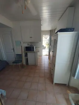 a kitchen with white cabinets and a tiled floor at ALBASUD - Appartement meublé avec terrasse - Salses le Chateau 66 in Salses-le-Chateau