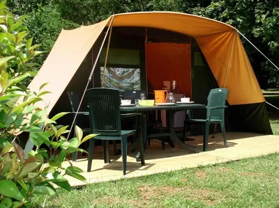a tent with a table and chairs in it at Chalet et mobil homes dans la montagne au Camping les Sapins in Camurac
