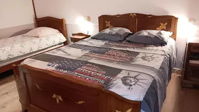 a bedroom with a large bed with a bedskirts at Gîte la Lanterne transition écologique avec borne de recharge 7kw Site sous vidéo protection in Nalzen