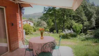 a table with a vase of flowers on a patio at Gîte la Lanterne transition écologique avec borne de recharge 7kw Site sous vidéo protection in Nalzen