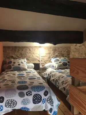 a bedroom with two twin beds and a lamp at Le Diable par la queue in Olargues