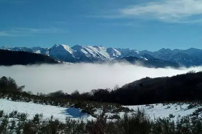 a view of a snow covered mountain range with clouds at la Chaumine aux étoiles in Camurac