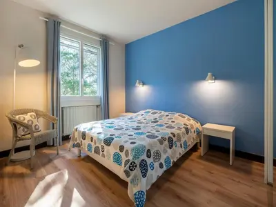 a bedroom with a bed and a blue wall at Lovely country house with private pool in Vieussan