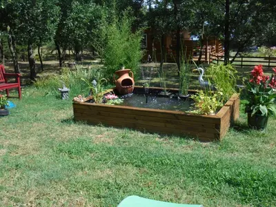 a garden with a bird bath in the grass at Chalet 2 pers. + Bébé in Montolieu