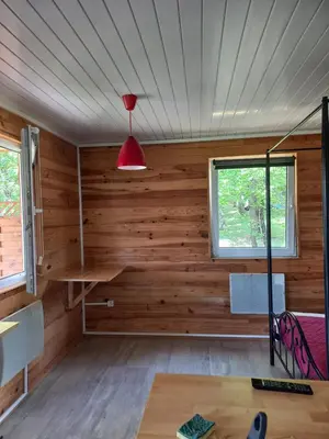 a room with wooden walls and a red lamp at Chalet 2 pers. + Bébé in Montolieu