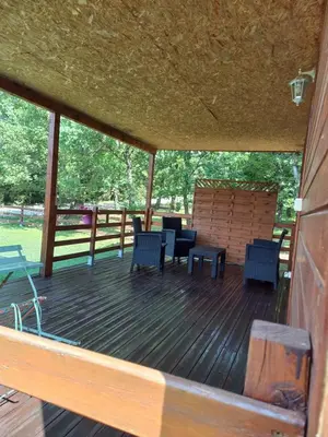 a large deck with chairs and tables on it at Chalet 2 pers. + Bébé in Montolieu