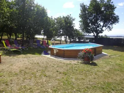a swimming pool in a yard with chairs and flowers at Chalet 2 pers. + Bébé in Montolieu