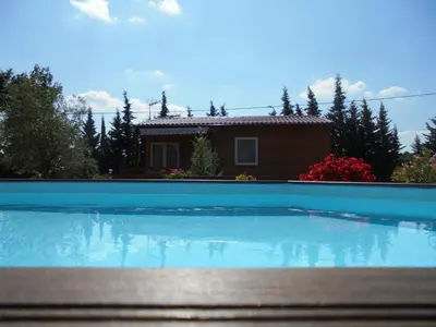a large swimming pool in front of a house at Chalet 4 personnes in Montolieu