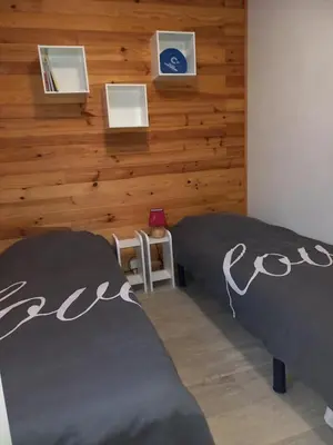 two beds in a room with a wooden wall at Chalet 4 personnes in Montolieu