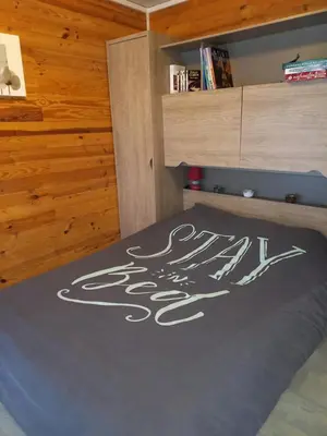 a bedroom with a bed with a sign on the floor at Chalet 4 personnes in Montolieu