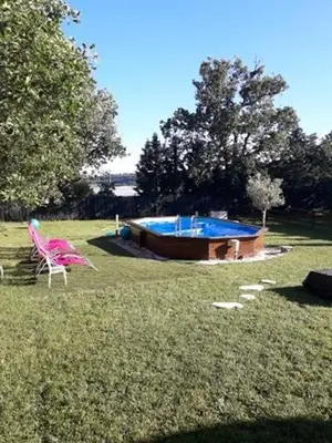 a yard with a pink chair and a swimming pool at Chalet 4 personnes in Montolieu