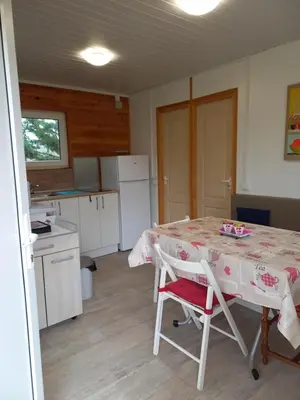 a kitchen with a table and chairs in a room at Chalet 4 personnes in Montolieu