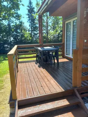 a wooden deck with a table and chairs on it at Chalet 4 personnes in Montolieu