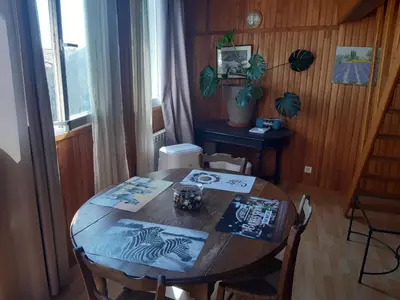 a wooden table with chairs and a table with a book on it at ETAPE DE ST COUAT in Saint-Couat-dʼAude