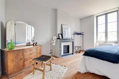 a bedroom with a bed and a mirror and a fireplace at TRIBUS-GITES URBAINS CARCASSONNE in Carcassonne
