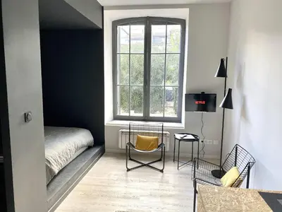 a bedroom with a bed and a window at TRIBUS-GITES URBAINS CARCASSONNE in Carcassonne