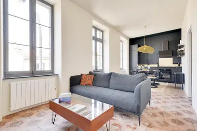 a living room with a couch and a table at TRIBUS-GITES URBAINS CARCASSONNE in Carcassonne