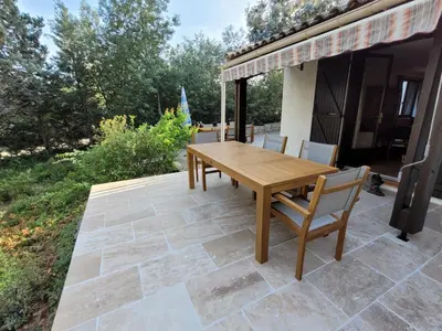 a wooden table and chairs on a patio at Villa w Garden & Guest House in Prades-sur-Vernazobre