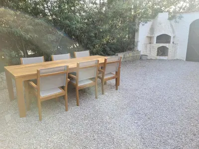 a wooden table and chairs on a gravel patio at Villa w Garden & Guest House in Prades-sur-Vernazobre