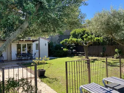 a garden with two picnic tables and a fence at Montbrun Vineyard Escape in Montbrun-des-Corbières