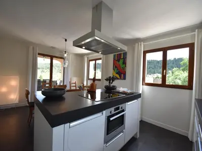 a kitchen with a black counter top and some windows at Villa with heated pool, jacuzzi, sports field and stunning views in Montbrun-des-Corbières