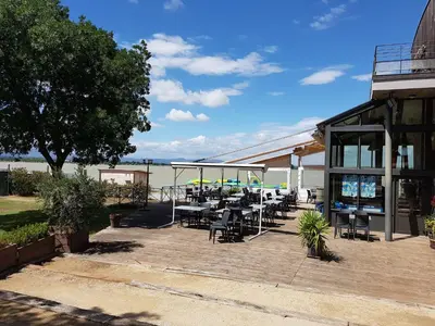 a patio with tables and chairs next to a building at Villa with heated pool, jacuzzi, sports field and stunning views in Montbrun-des-Corbières