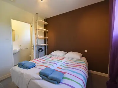 a bedroom with a bed with two blue towels on it at Villa with heated pool, jacuzzi, sports field and stunning views in Montbrun-des-Corbières