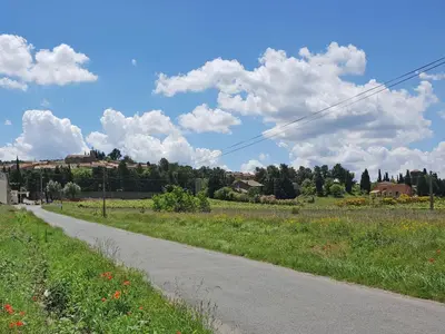 an empty road in a field with clouds in the sky at Villa with heated pool, jacuzzi, sports field and stunning views in Montbrun-des-Corbières