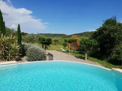 a large blue swimming pool in a garden at Villa with heated pool, jacuzzi, sports field and stunning views in Montbrun-des-Corbières