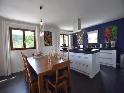 a kitchen and dining room with a wooden table at Villa with heated pool, jacuzzi, sports field and stunning views in Montbrun-des-Corbières
