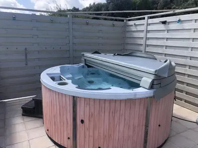 a hot tub sitting on top of a patio at Villa Retreat with Pool and pets in Vélieux