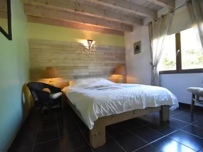 a bedroom with a bed and a desk and a window at Villa Retreat with Pool and pets in Vélieux