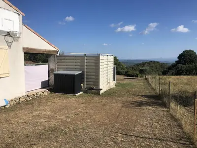 a building with a garage next to a fence at Villa Retreat with Pool and pets in Vélieux