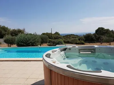 a jacuzzi tub sitting next to a swimming pool at Villa Retreat with Pool and pets in Vélieux