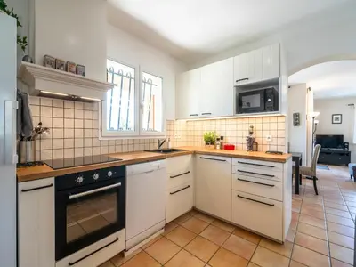 a kitchen with white cabinets and a black oven at Villa in Escales with Private Pool in Escales