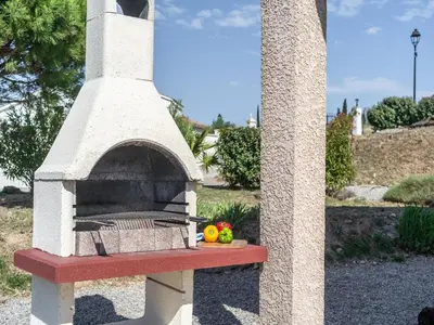 a stone oven with a plate of fruit on a table at Villa in Escales with Private Pool in Escales