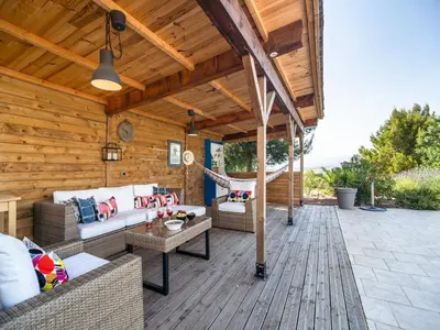 a wooden patio with couches and a hammock at Villa in Escales with Private Pool in Escales
