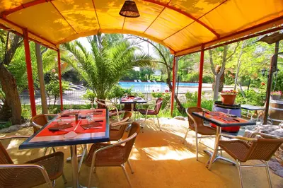 a wooden deck with a table and chairs on a tent at Camping la Peiriere - Lodge en Pays Cathare in Tuchan