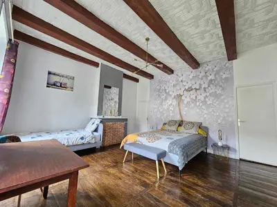 a bedroom with a bed and a table in it at Bastide du Thoré in Labastide-Rouairoux