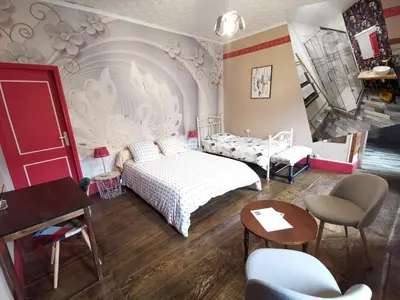 a bedroom with a bed and a table and chairs at Bastide du Thoré in Labastide-Rouairoux
