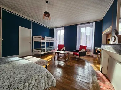a bedroom with blue walls and a bed and a living room at Bastide du Thoré in Labastide-Rouairoux