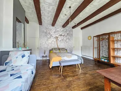 a bedroom with a bed and a couch in it at Bastide du Thoré in Labastide-Rouairoux
