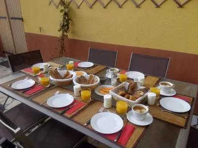 a wooden table with breakfast foods and cups of orange juice at L'Art de Vivre in Latour-de-France