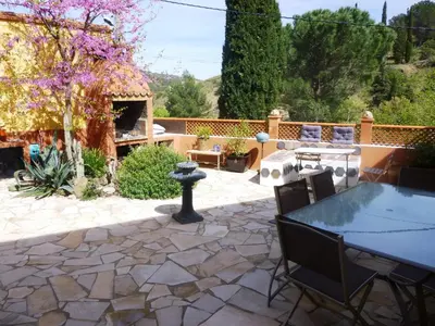 a patio with a table and chairs and a fire pit at L'Art de Vivre in Latour-de-France