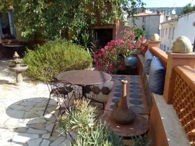 a patio with a table and chairs and flowers at L'Art de Vivre in Latour-de-France