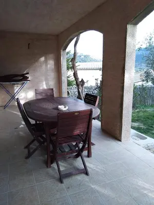 a wooden table and chairs on a patio at Les lavandes in Duilhac